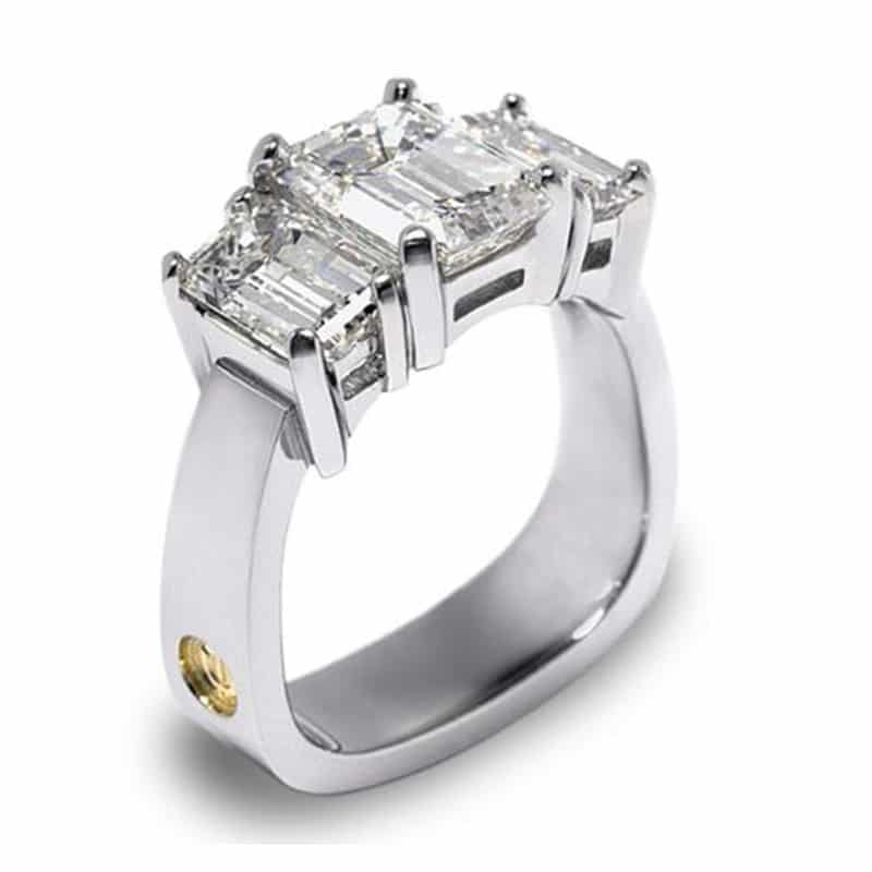 Classique Platinum three-stone emerald cut diamond ring featuring three rectangular diamonds set in a sleek platinum band.