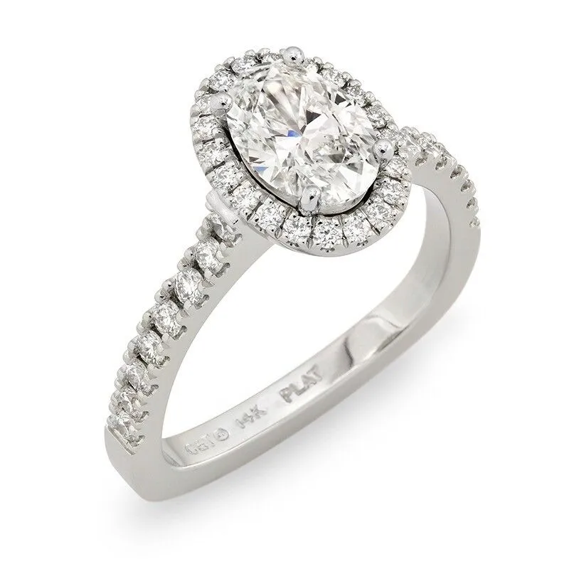 Oval diamond halo engagement ring with pave-set diamonds on a platinum band, showcasing elegance and luxury.