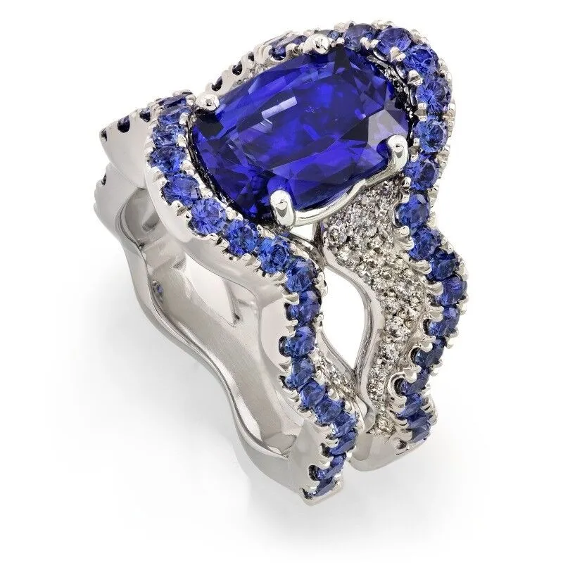 Crescendo Bi-Color Tourmaline and Diamond Pave Ring featuring a central blue sapphire surrounded by sparkling diamonds, set in a luxurious platinum band.